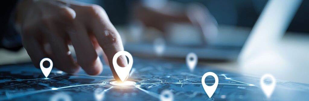 Qu’est-ce que le Géorepérage (Geofencing) et quels sont ses avantages pour les entreprises? 1 Une main touchant une tablette affichant une carte numérique avec plusieurs points de localisation lumineux. L’image illustre l’utilisation d’un logiciel de gestion de flotte pour la géolocalisation, le geofencing et le suivi GPS en temps réel des actifs ou véhicules.